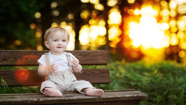 Baby Boy sitting on a Bench in beautiful Light